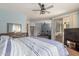 Bright bedroom featuring a ceiling fan, a door to another bedroom, and a sliding door to the patio at 18415 W Capistrano Ave, Goodyear, AZ 85338