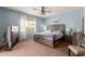 Cozy bedroom featuring a ceiling fan, comfortable bed, and natural light from the window at 18415 W Capistrano Ave, Goodyear, AZ 85338