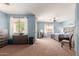 Spacious bedroom with neutral carpet, a ceiling fan, and large windows for ample natural light at 18415 W Capistrano Ave, Goodyear, AZ 85338