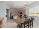 Well-lit dining area features wood table and chairs, a modern chandelier, and seamlessly connects to the kitchen at 18415 W Capistrano Ave, Goodyear, AZ 85338