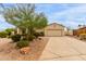 Charming single-story home with a two-car garage, desert landscaping, and a concrete driveway at 18415 W Capistrano Ave, Goodyear, AZ 85338