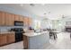 Bright kitchen with a view into the living room, boasting wood cabinets and black appliances at 18415 W Capistrano Ave, Goodyear, AZ 85338