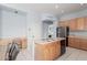 Bright kitchen showcases a central island, built-in desk, and wooden cabinetry at 18415 W Capistrano Ave, Goodyear, AZ 85338