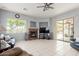 Inviting living room featuring a stone fireplace, sliding glass doors, and tile flooring at 18415 W Capistrano Ave, Goodyear, AZ 85338
