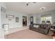 Spacious living room featuring tile flooring, a ceiling fan, and a cozy seating area at 18415 W Capistrano Ave, Goodyear, AZ 85338