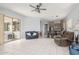 Open-concept living room features a ceiling fan, sliding glass doors, and flows into the dining area and kitchen at 18415 W Capistrano Ave, Goodyear, AZ 85338