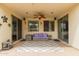 Covered patio with decorative turtle wall art, ceiling fan and furniture at 18415 W Capistrano Ave, Goodyear, AZ 85338