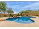 Stunning pool with rock waterfall feature, surrounded by lush landscaping, creating a backyard oasis at 18415 W Capistrano Ave, Goodyear, AZ 85338