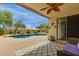 L-shaped pool with beautiful waterfall surrounded by landscaping and patio furniture at 18415 W Capistrano Ave, Goodyear, AZ 85338