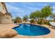 Beautiful pool features a rock waterfall and desert landscaping, creating a perfect backyard retreat at 18415 W Capistrano Ave, Goodyear, AZ 85338