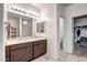Bright bathroom with a double sink vanity, tile flooring, and a walk-in closet at 18662 W Foothill Dr, Surprise, AZ 85387