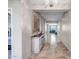 Bright hallway featuring tile flooring and decorative lighting fixtures leading to various living spaces at 18662 W Foothill Dr, Surprise, AZ 85387
