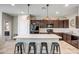 Modern kitchen featuring stainless steel appliances, dark cabinetry, a large island, and pendant lighting at 18662 W Foothill Dr, Surprise, AZ 85387