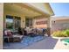 Covered patio with comfortable seating, string lights, and a view of the pool at 18662 W Foothill Dr, Surprise, AZ 85387
