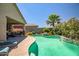 Backyard oasis featuring a refreshing pool, lush landscaping, and a cozy patio seating area at 18662 W Foothill Dr, Surprise, AZ 85387