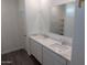 Stylish bathroom with double sinks, white cabinetry, and a large mirror; wood-look tile floors at 18795 E Bruno Dr, Gold Canyon, AZ 85118