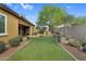 Expansive backyard with lush artificial grass, beautiful landscaping, and patio seating at 19291 E Thornton Rd, Queen Creek, AZ 85142
