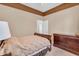 Comfortable bedroom with coffered ceiling, neutral walls, and a wood dresser at 19291 E Thornton Rd, Queen Creek, AZ 85142