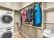 Organized walk-in closet with shelving, hanging rods, a stacked washer/dryer, and folded towels at 19291 E Thornton Rd, Queen Creek, AZ 85142