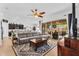 Comfortable living room with a large sectional, open to the modern kitchen and bright backyard at 19291 E Thornton Rd, Queen Creek, AZ 85142