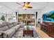 Bright living room with ample seating, a ceiling fan, and a sliding glass door to the patio at 19291 E Thornton Rd, Queen Creek, AZ 85142