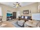 Cozy living room featuring a comfortable couch, armchair and a tv entertainment center at 19291 E Thornton Rd, Queen Creek, AZ 85142