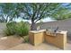 Modern outdoor kitchen with stainless steel grill surrounded by desert landscaping at 19291 E Thornton Rd, Queen Creek, AZ 85142