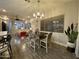 Open-concept dining area featuring stylish chairs, a modern chandelier, and access to the living area at 2042 W Periwinkle Way, Chandler, AZ 85248