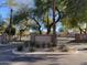 Gated entrance with iron gates, landscaping, and mature trees offering privacy and security to the neighborhood at 2042 W Periwinkle Way, Chandler, AZ 85248