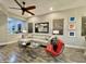 Comfortable living room featuring wood-look tile flooring, a ceiling fan, and modern furnishings at 2042 W Periwinkle Way, Chandler, AZ 85248