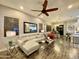 Inviting living room featuring wood-look tile flooring, a modern ceiling fan, and stylish decor at 2042 W Periwinkle Way, Chandler, AZ 85248