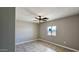 This bedroom features neutral walls, tiled floor, a ceiling fan and a window at 20435 W Mountain Sage Dr, Buckeye, AZ 85326