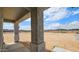 Covered patio offering stunning desert views, supported by sturdy columns and featuring an outdoor lantern at 20435 W Mountain Sage Dr, Buckeye, AZ 85326