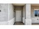 A bright white front door highlighted by an exterior lantern, set against stucco walls and trim at 20435 W Mountain Sage Dr, Buckeye, AZ 85326