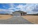 Attractive single-story home with a neutral stucco exterior, a two-car garage and desert landscaping under a blue sky at 20435 W Mountain Sage Dr, Buckeye, AZ 85326