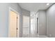 Neutral hallway with tiled floors featuring multiple doorways at 20435 W Mountain Sage Dr, Buckeye, AZ 85326