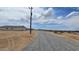 Newly constructed houses on a gravel road with expansive desert views under a blue sky at 20435 W Mountain Sage Dr, Buckeye, AZ 85326