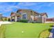 Beautiful backyard with artificial turf, putting green, and covered patio for outdoor enjoyment at 22262 E Cherrywood Ct, Queen Creek, AZ 85142
