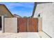 Backyard fence with a wooden gate, providing security and privacy for the property's outdoor space at 22262 E Cherrywood Ct, Queen Creek, AZ 85142