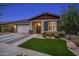 Charming single-story home featuring a two-car garage, manicured lawn, and inviting entryway at 22262 E Cherrywood Ct, Queen Creek, AZ 85142