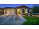 Charming single-story home featuring a two-car garage, manicured lawn, and inviting entryway at 22262 E Cherrywood Ct, Queen Creek, AZ 85142