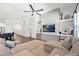 Bright living room featuring a modern fireplace wall, ceiling fan, and comfortable seating with a view to kitchen at 22262 E Cherrywood Ct, Queen Creek, AZ 85142
