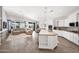 Open-concept living space featuring kitchen island, dining area and living room with neutral tones and sliding doors to outside at 22262 E Cherrywood Ct, Queen Creek, AZ 85142