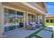 Relaxing covered patio featuring stylish outdoor furniture and artificial turf accents at 22262 E Cherrywood Ct, Queen Creek, AZ 85142
