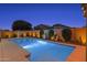 Backyard pool with desert landscaping and illuminated hardscape at 22262 E Cherrywood Ct, Queen Creek, AZ 85142
