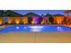 Sparkling pool with basketball hoop, desert plants, and ambient lighting at 22262 E Cherrywood Ct, Queen Creek, AZ 85142