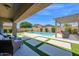 Backyard features a covered patio, pool, and grassy areas at 22262 E Cherrywood Ct, Queen Creek, AZ 85142