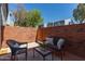 Charming outdoor patio with comfortable seating, brick accent wall, and secure wooden gate at 2301 E University Dr # 233, Mesa, AZ 85213
