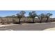 Backyard view of black fence with desert landscaping and trees in the background at 2411 W Lucia Dr, Phoenix, AZ 85085