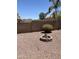 This desert-landscaped backyard features a charming stone fire pit and lush greenery at 2411 W Lucia Dr, Phoenix, AZ 85085